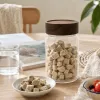 Heart-shaped brown lecithin slimming and shaping tablets in a transparent glass jar with a wooden lid details Picture